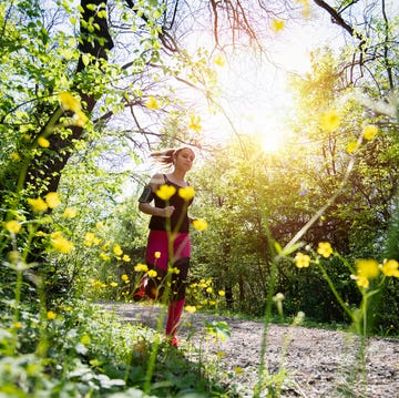 young sporty woman jogging through the forest