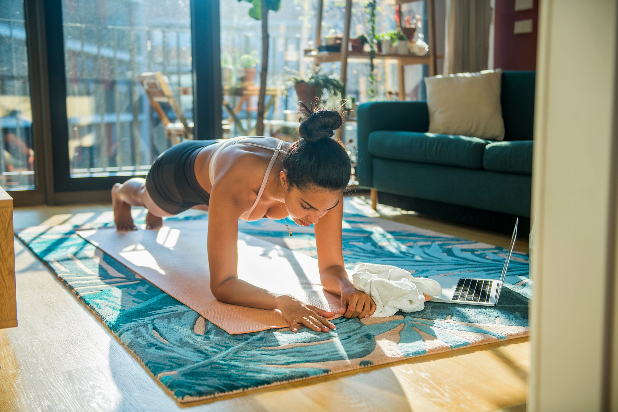 Young sporty woman practicing yoga, doing strengthening exercises