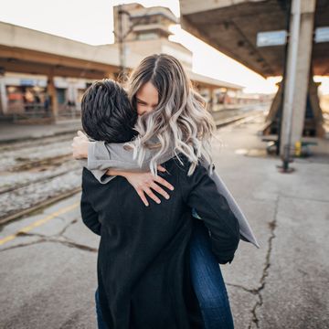 young teenage couple hugging on the train station