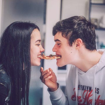 a man and a woman eating pizza