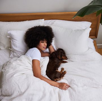 jonge vrouw met hond in bed