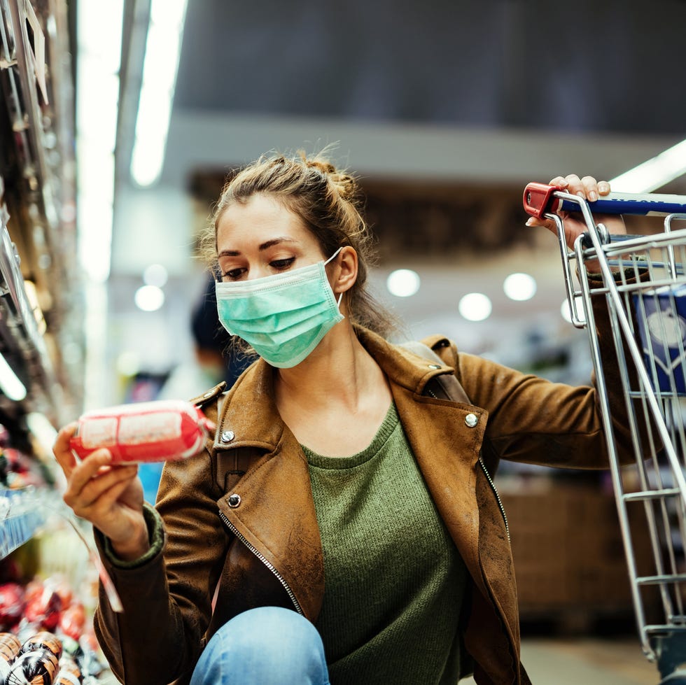 Young woman buying groceries while wearing face mask in the supermarket. young woman buying groceries while wearing face mask in the supermarket