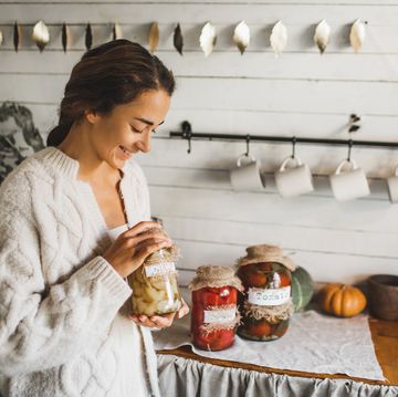 young woman cans and pickles vegetables.