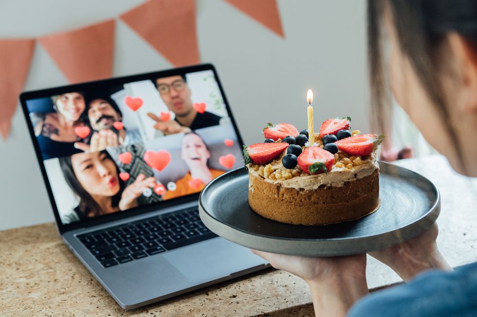 young woman celebrating birthday with friends on a video call using laptop