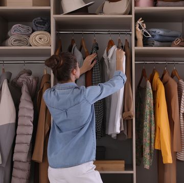 young woman choosing clothes in wardrobe