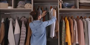 young woman choosing clothes in wardrobe