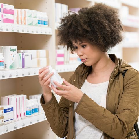 young woman choosing supplement in drugstore