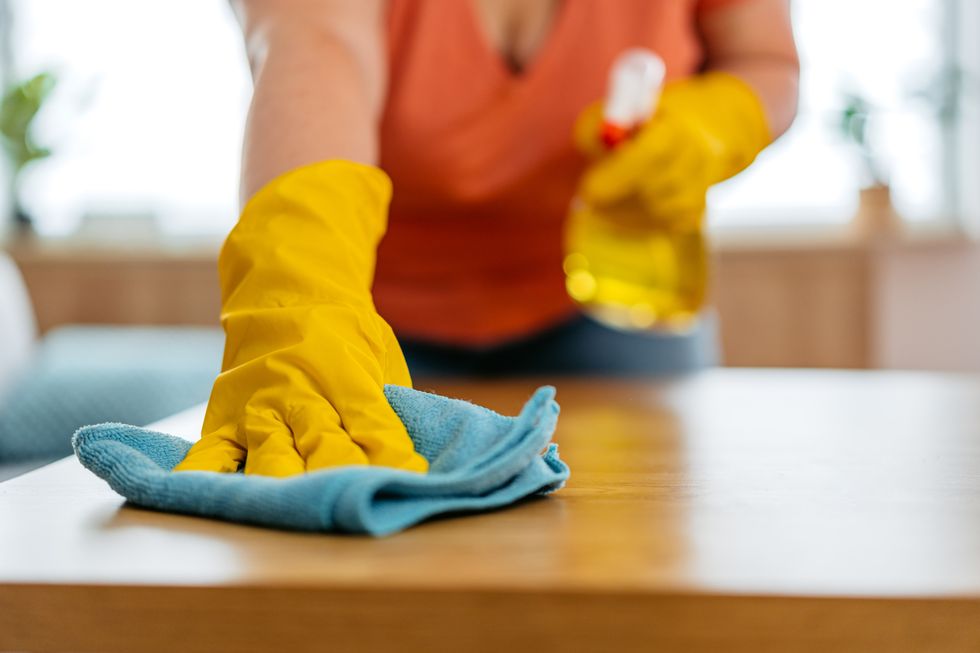 young woman cleaning her dining table at home