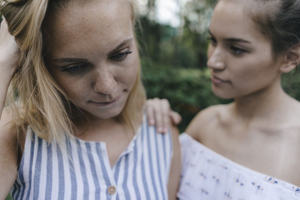 young woman comforting sad female friend