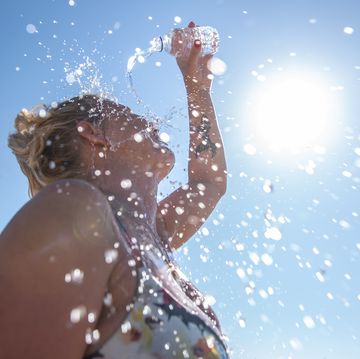 a young woman cools down with cold water during the summer heat