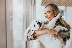 young woman cuddles her 12 week old golden retriever puppy