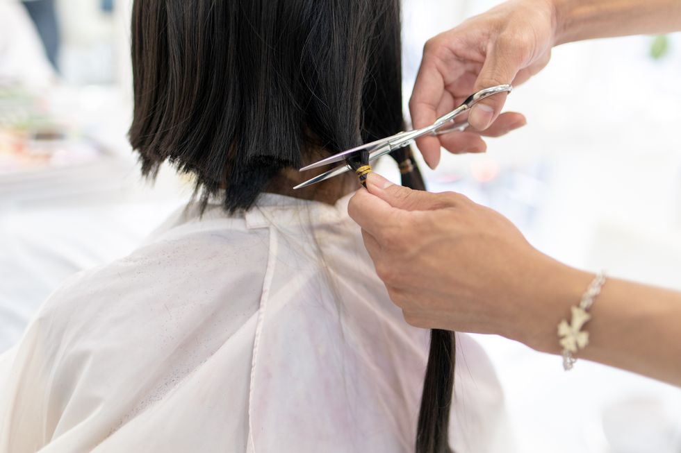 young woman cutting hair for donation