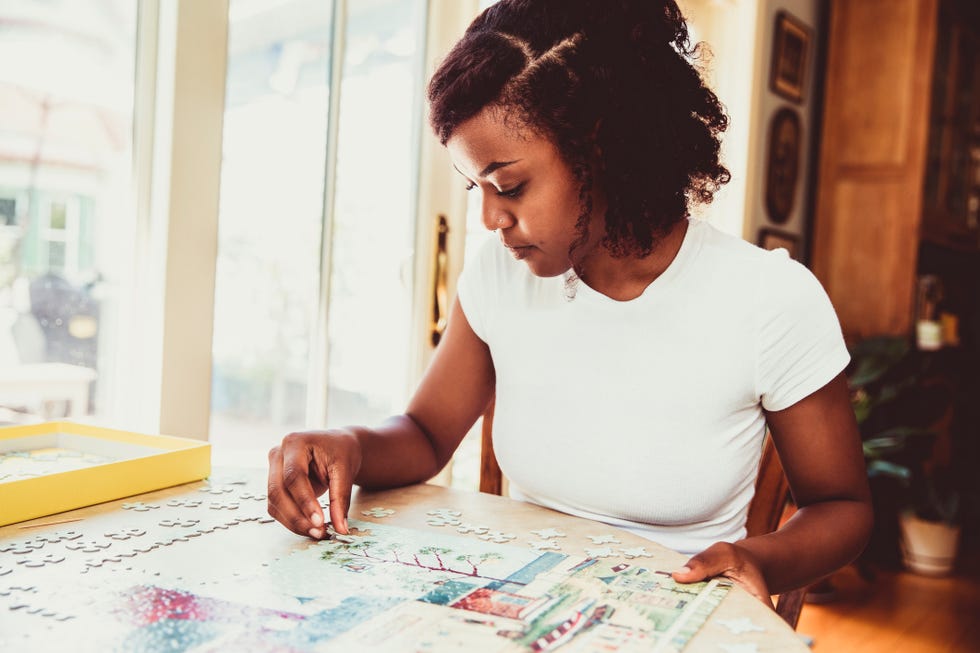 young woman doing a puzzle at home