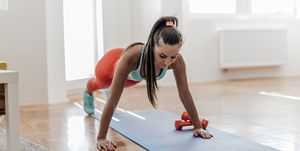 Young woman doing some push ups in her living room