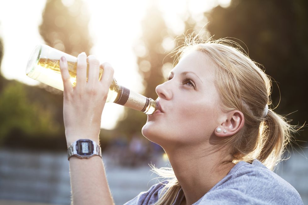 young woman drinking beer of a bottle