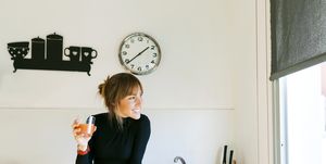 young woman drinking fresh grapefruit juice in her kitchen