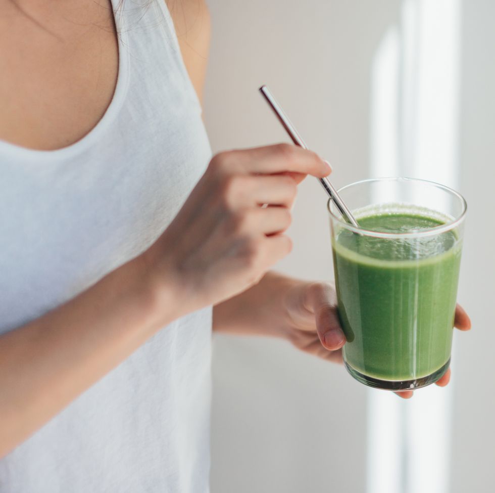 young woman drinking green juice for cleanse diet