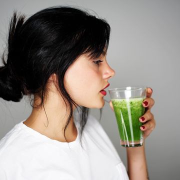 mujer bebiendo un zumo verde detox