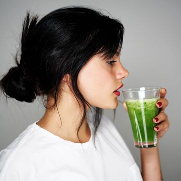 mujer bebiendo un zumo verde detox