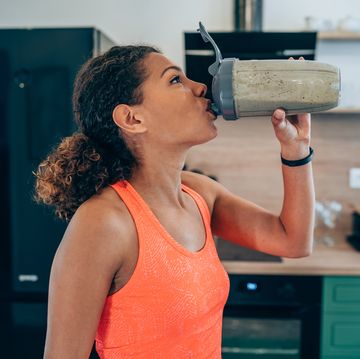 young woman drinking pre workout shake before the gym