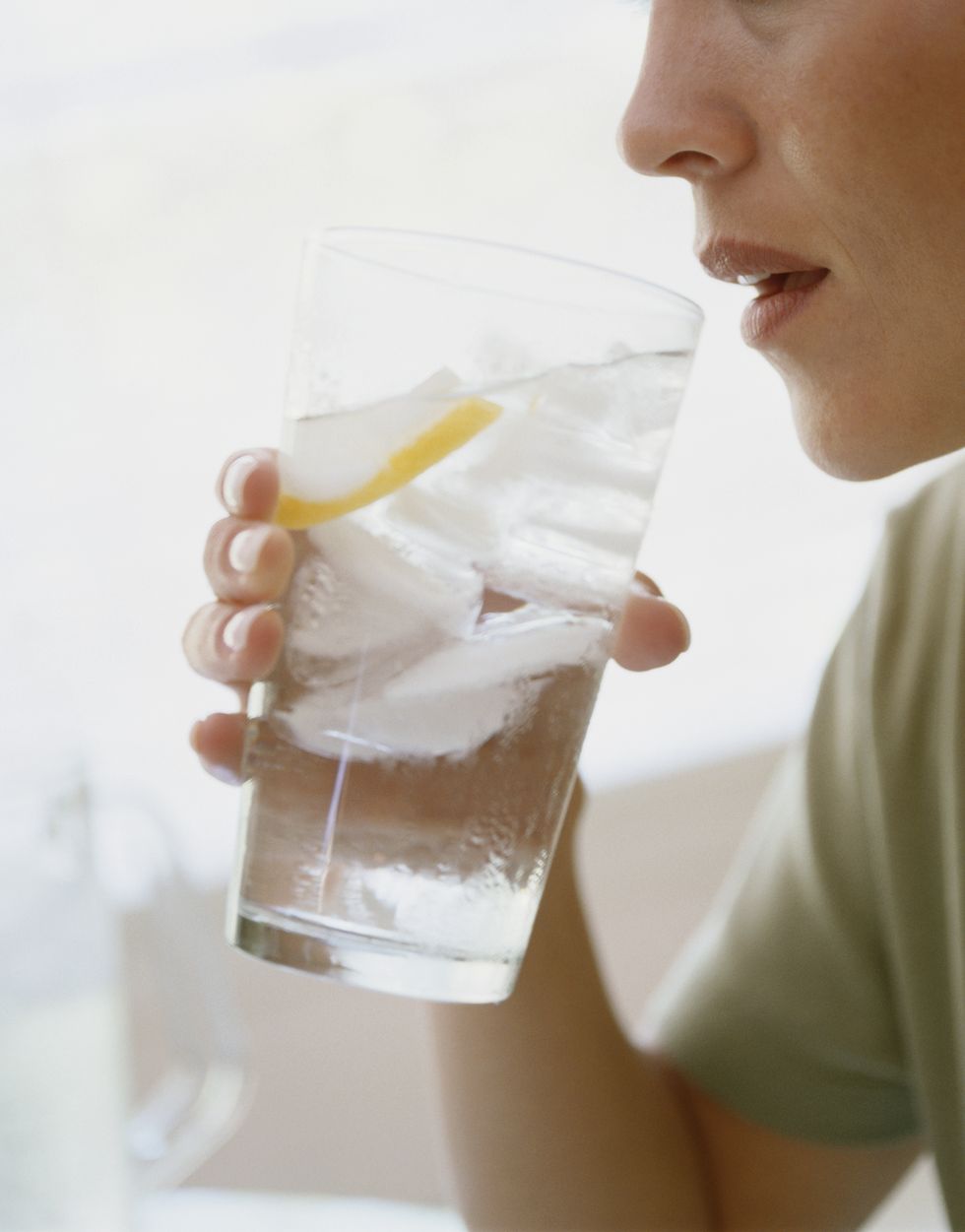 young woman drinking water, side view, close up