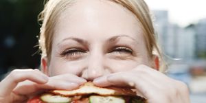 young woman eating a hamburger