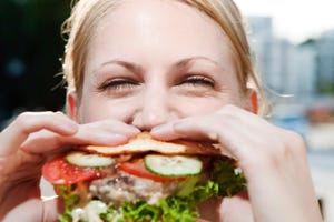 young woman eating a hamburger