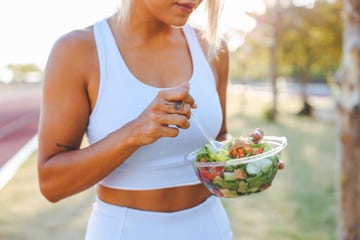 young woman eating a healthy salad after workout fitness and healthy lifestyle concept