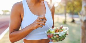 young woman eating a healthy salad after workout fitness and healthy lifestyle concept