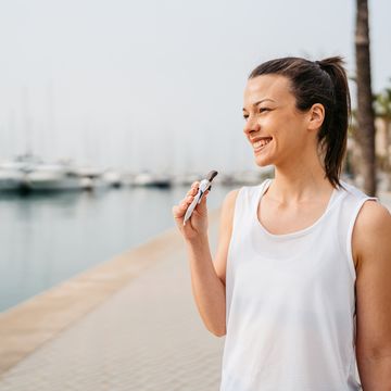 young woman eating a protein bar after training on the quayside in palma de mallorca in spain