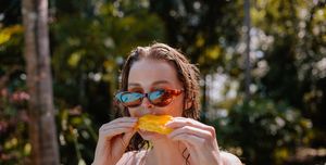 young woman eating mango on vacation
