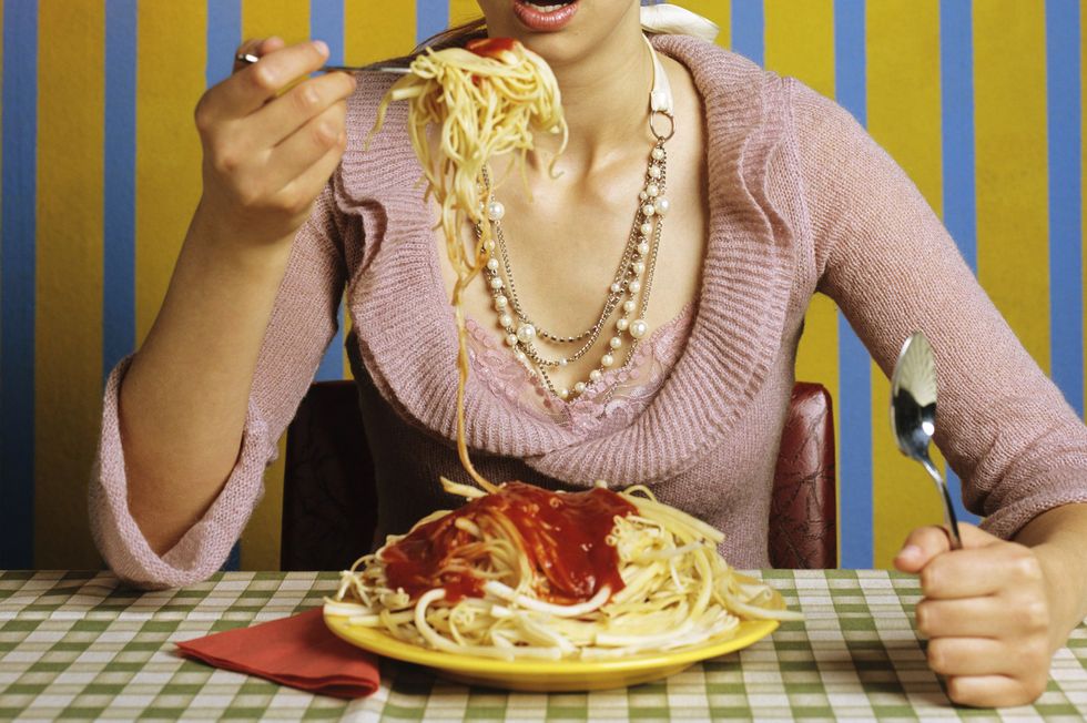 young woman eating spaghetti