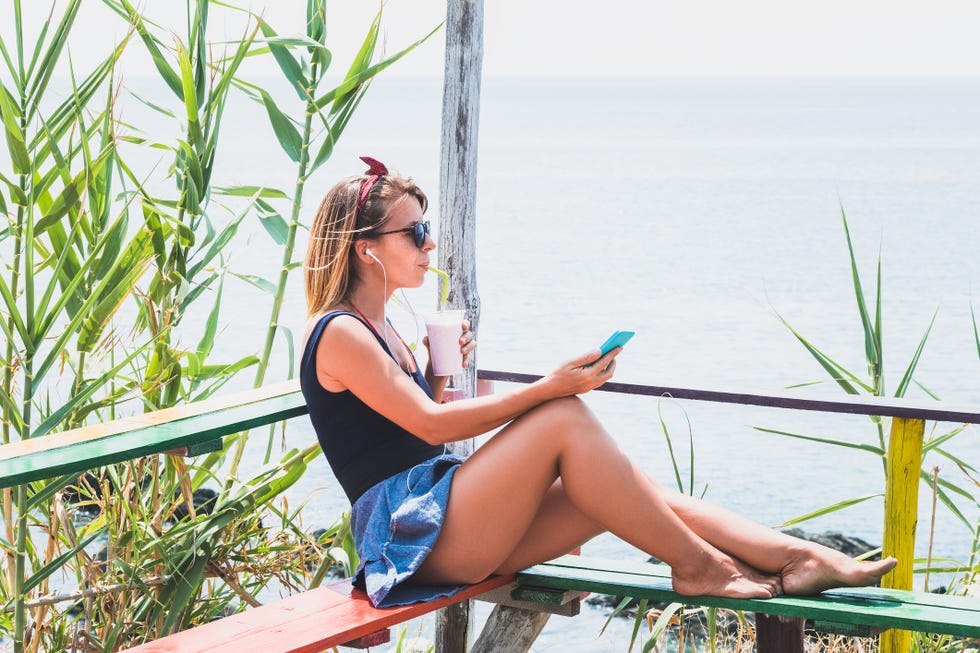 young woman enjoying cold drink in a beach bar