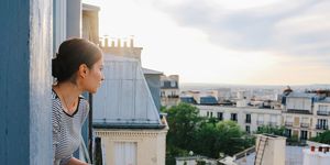 young woman enjoying the view from a parisian apartment