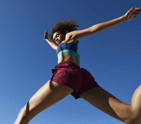 young woman exercising against clear sky