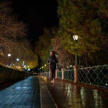 young woman exercising in public park, outdoors at night