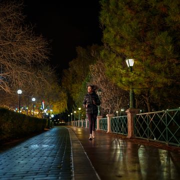 young woman exercising in public park, outdoors at night