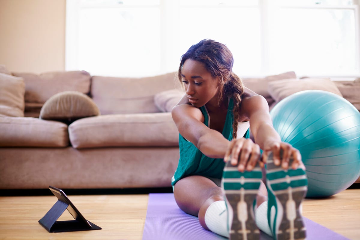 Young ethnic woman with fit ball sitting on floor while training in modern  gym · Free Stock Photo