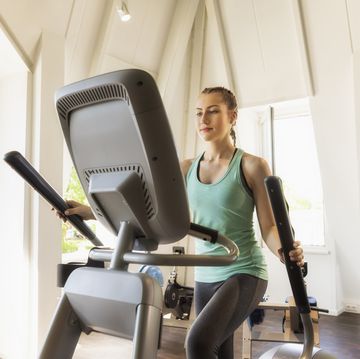 young woman exercising on step machine in fitness gym