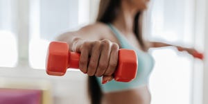 exercises for weight loss  young woman exercising with her weights in the living room