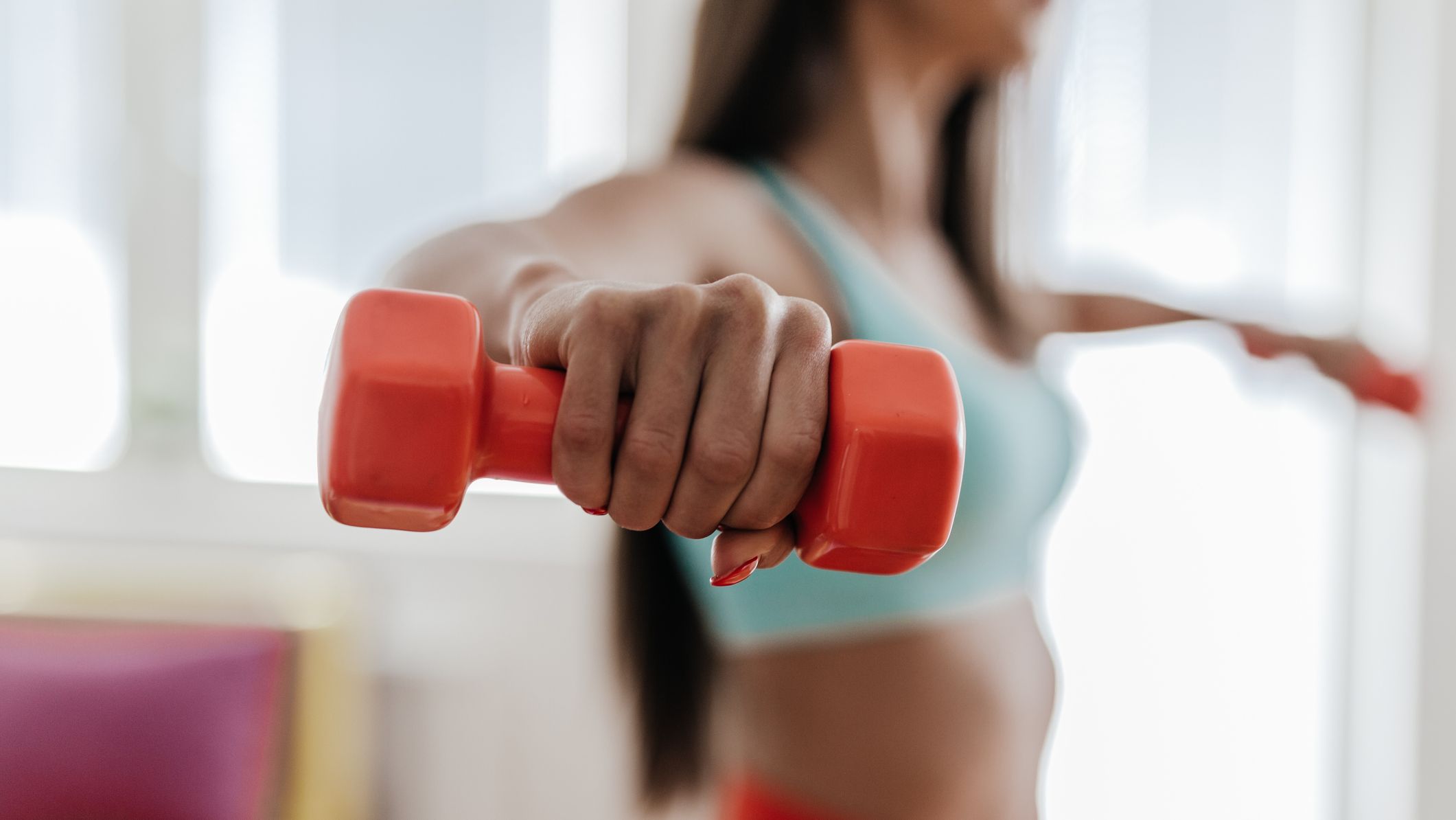https://hips.hearstapps.com/hmg-prod/images/young-woman-exercising-with-her-weights-in-the-royalty-free-image-1697151024.jpg?crop=1xw:0.84415xh;center,top