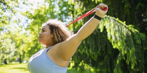 young woman exercising with resistance band outdoors