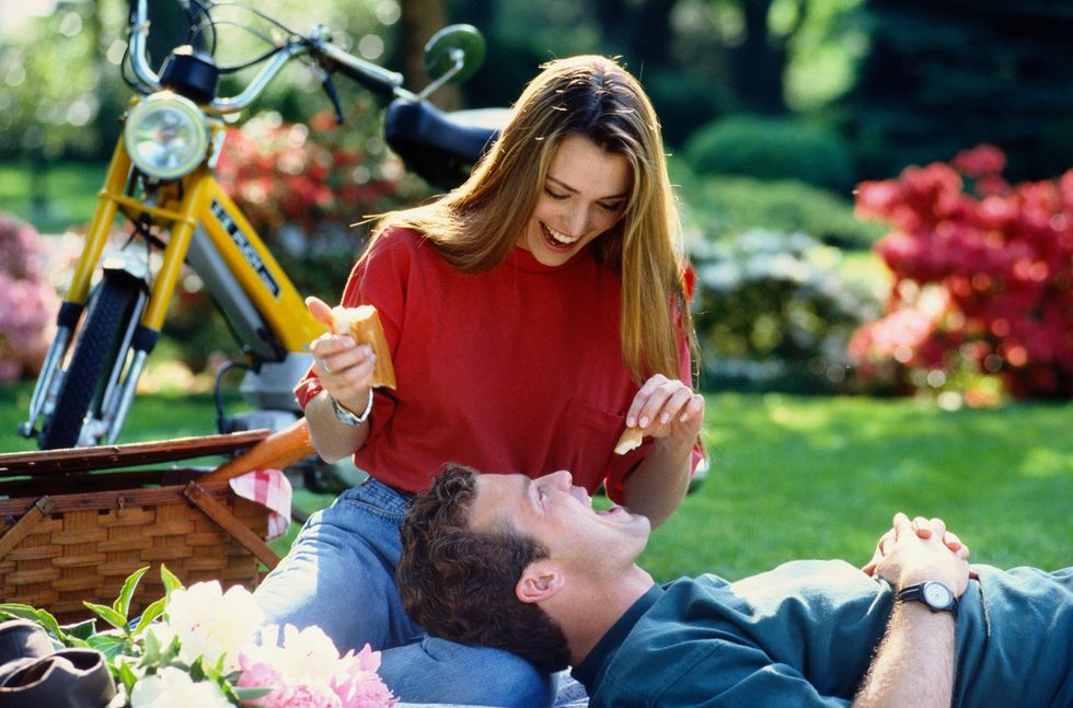 young woman feeding man on picnic
