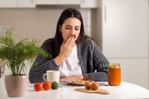 young  woman feeling nausea during breakfast time