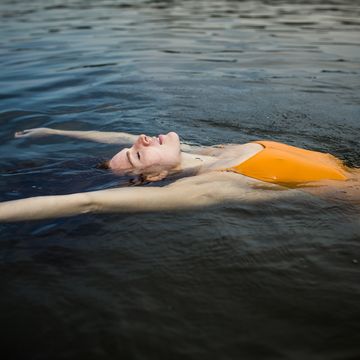 young woman floating in the water at lake