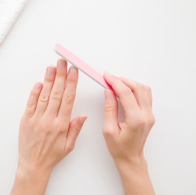 young woman hands using nail file