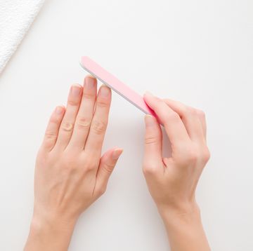 young woman hands using nail file