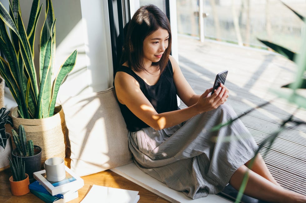 young woman having video call at home with plants