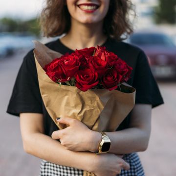 young woman holding beautiful red roses