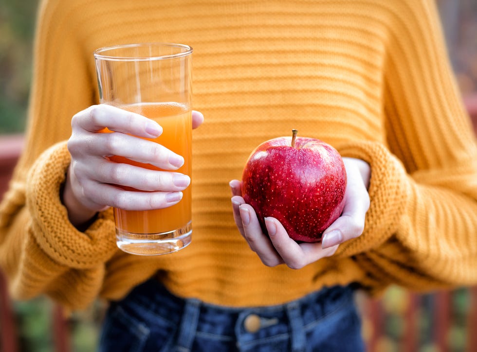 Young woman holding glass of apple juice and fresh apple Young woman holding glass of apple juice and fresh apple